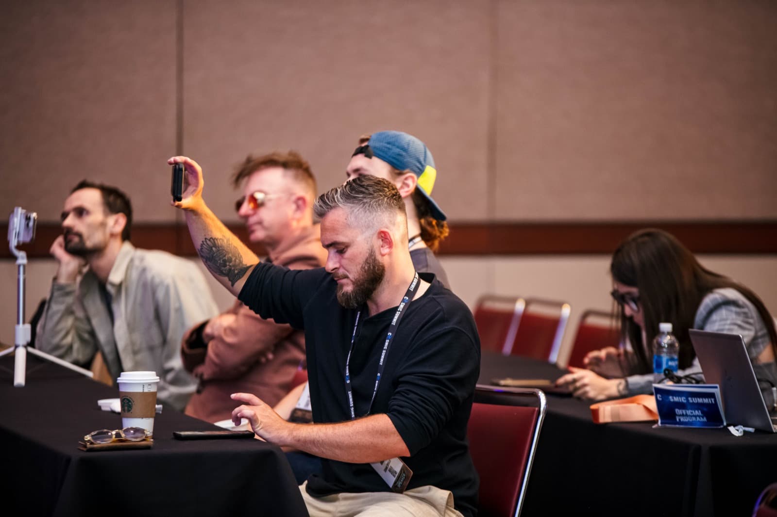 Attendees filming a talk from their table at Cosmic Summit