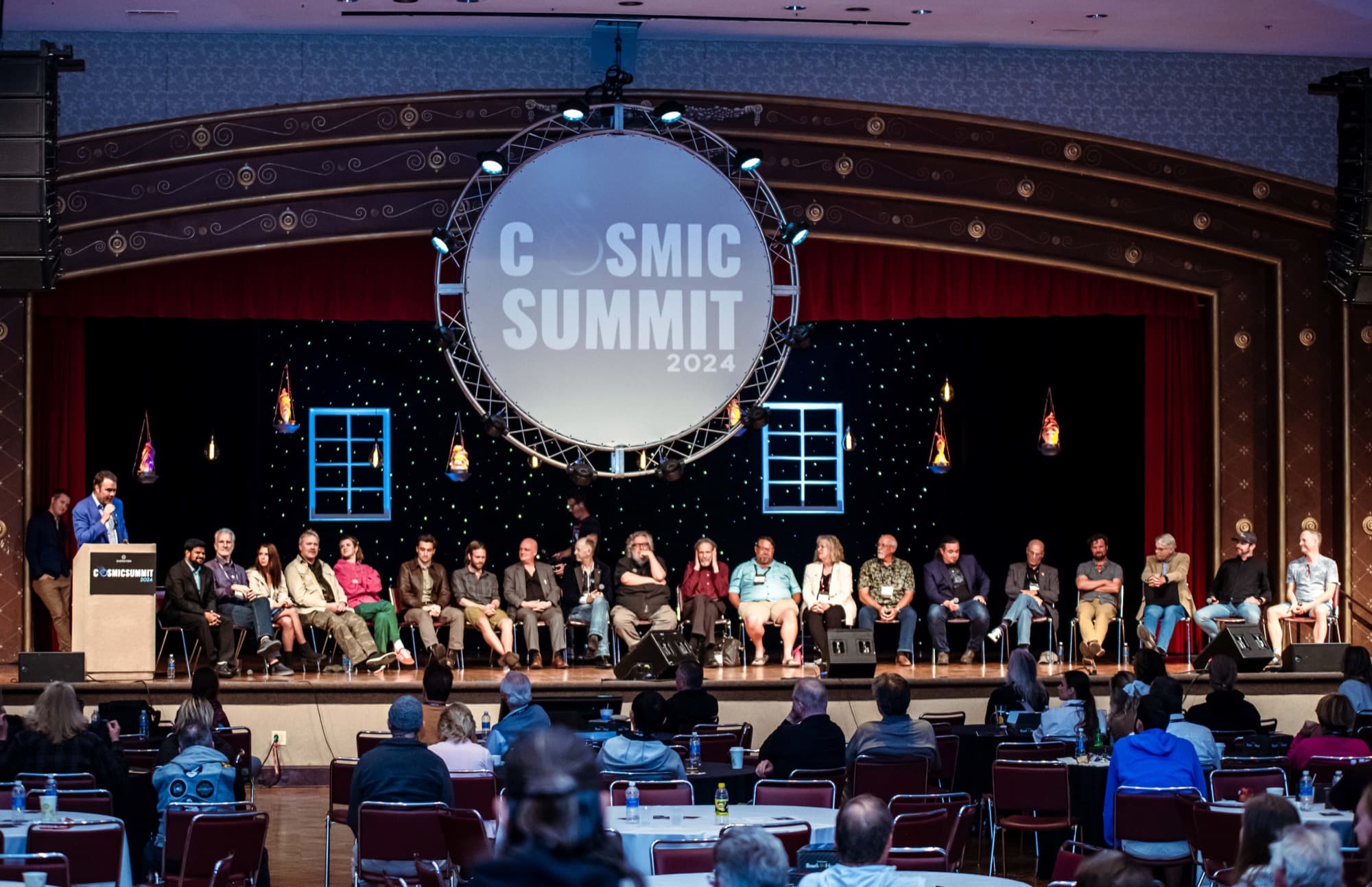 The Cosmic Summit 2024 speakers seated together on stage in front of the audience