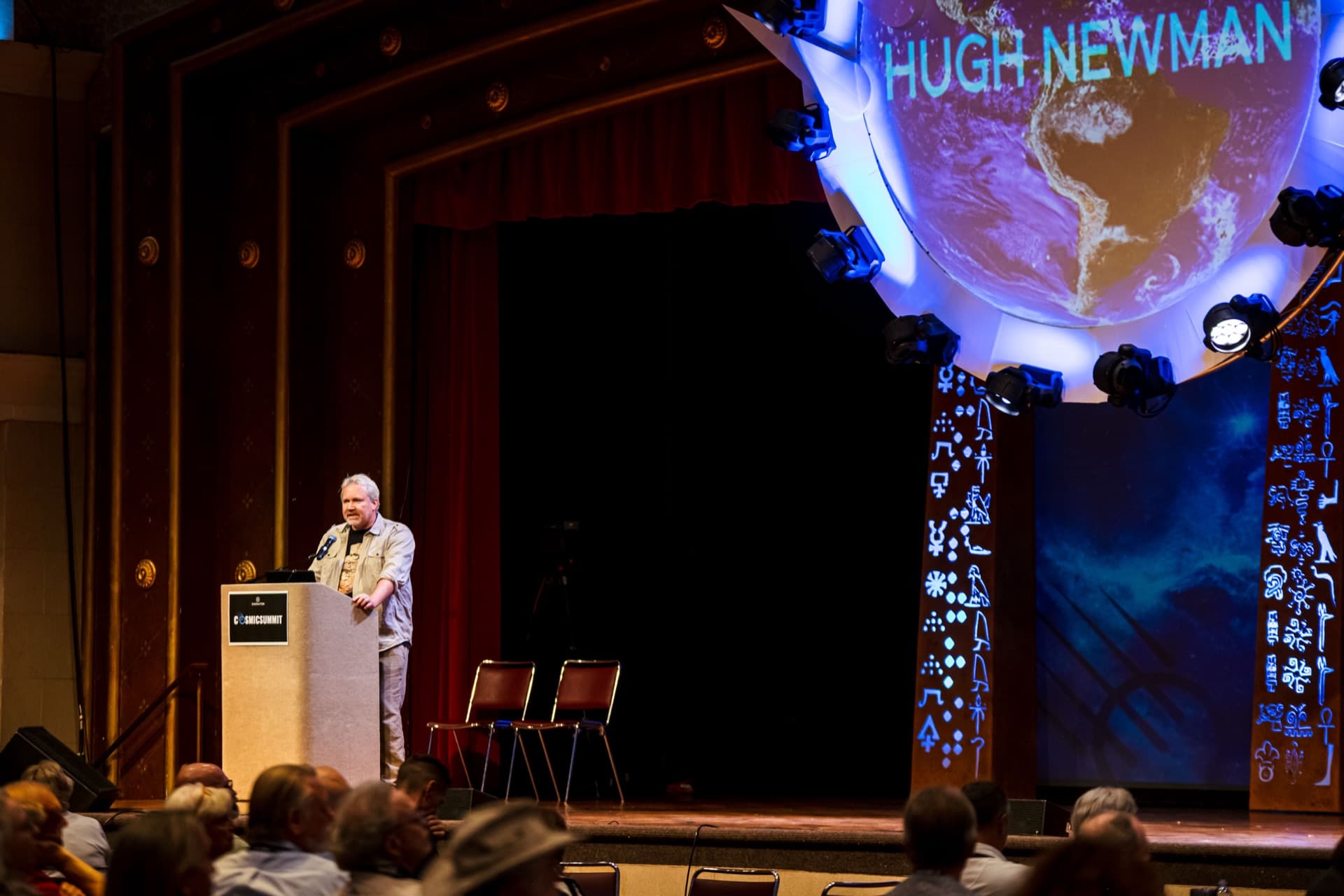 Cosmic Summit speaker reading host-read sponsor copy on stage