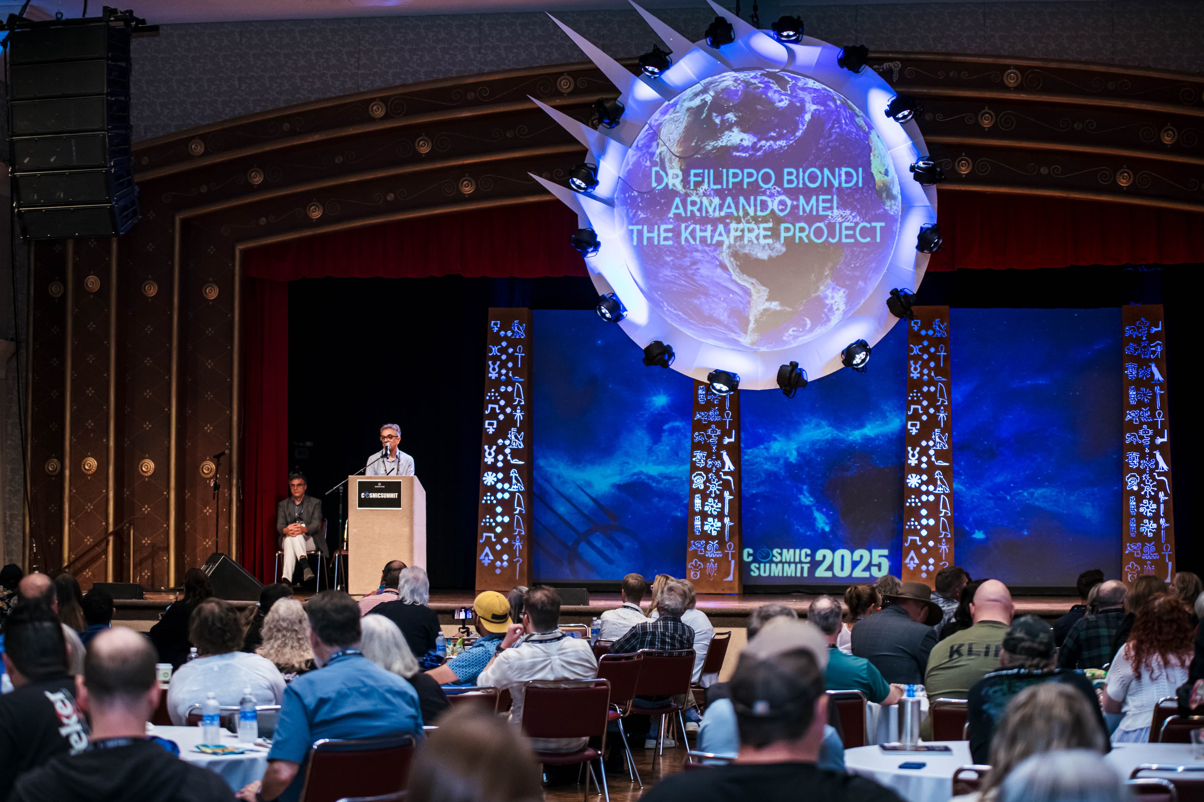 Cosmic Summit conference with speakers presenting to a live audience